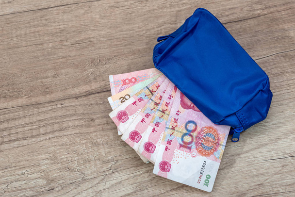 yuan banknote in blue wallet on desk. - Photo, image