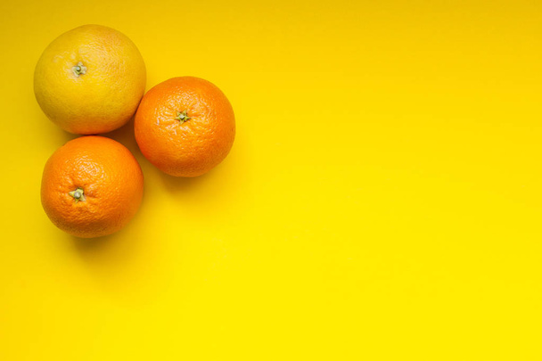 Όμορφη δύο πορτοκάλια πορτοκάλι και ένα γκρέιπφρουτ. Ζουμερά τροπικά  - Φωτογραφία, εικόνα