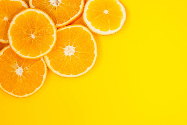 Round slices of orange lie on a yellow background, they have a l - Photo, Image
