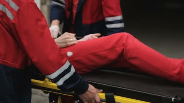 Zdravotníci nošení nosítka s poškozeným v nehodě do budovy nemocnice - Záběry, video