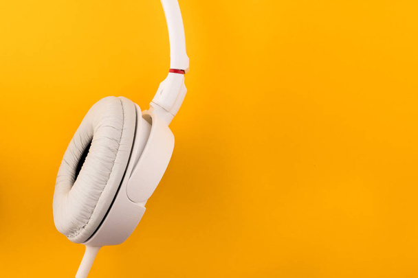 White headphones on a yellow background - Foto, imagen