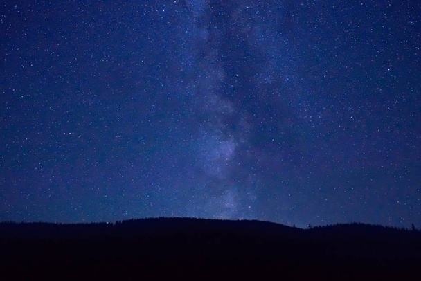Noche cielo azul oscuro con estrellas y galaxia de la Vía Láctea sobre la montaña
 - Foto, Imagen
