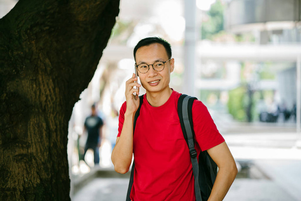 middle-aged Asian man with phone in city - Foto, Imagen