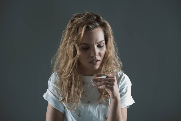 Stressed woman holding cigarette in hand - Fotó, kép