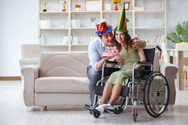 Młoda rodzina świętująca urodziny z osobą niepełnosprawną - Zdjęcie, obraz