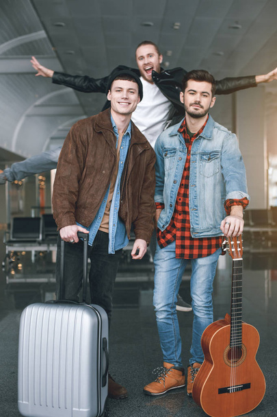 Happy comrades with luggages standing in airport - Zdjęcie, obraz
