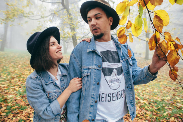 Lovely couple wearing denim clothes walking in autumnal park. - Fotografie, Obrázek