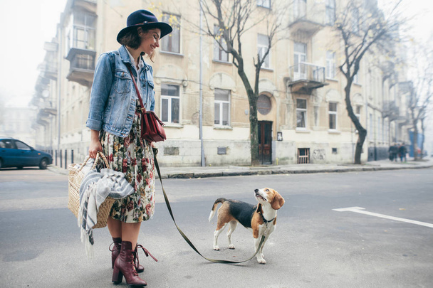 Woman walking beagle dog in town. - Zdjęcie, obraz