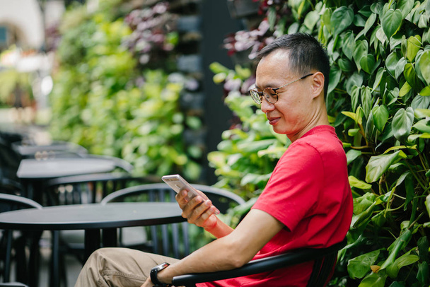 middle-aged Asian man with phone in city - Foto, immagini