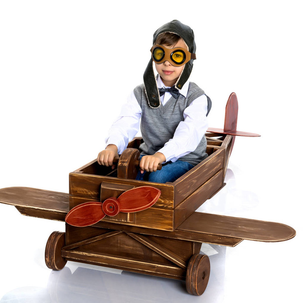 Little boy with a wooden plane. - Foto, imagen