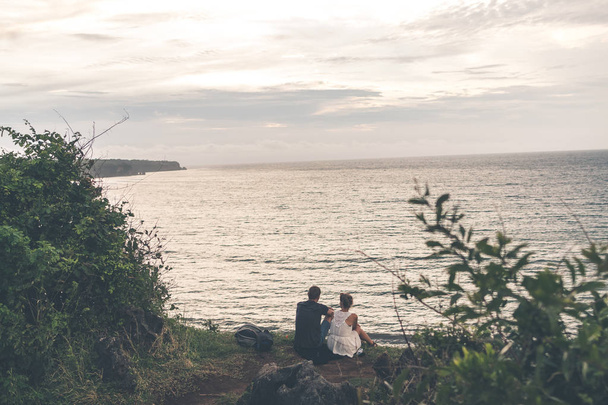 A couple is standing on the edge of mountain on a tropical Bali island. - Foto, afbeelding