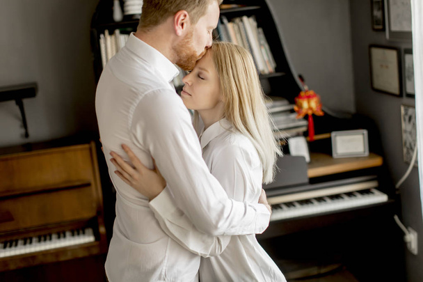 Amar a la joven pareja riendo, abrazando y divirtiéndose en la habitación
 - Foto, Imagen