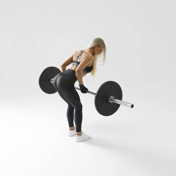Fit young woman lifting barbell - Valokuva, kuva