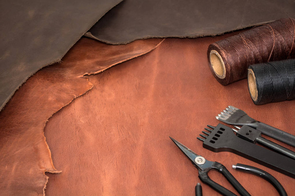 Herramientas para la elaboración de cuero y piezas de cuero marrón. Fabricación de cuero
 - Foto, Imagen