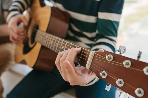 Learning to play the guitar. Music education and extracurricular lessons. Hobbies and enthusiasm for playing guitar and singing songs. - Photo, Image