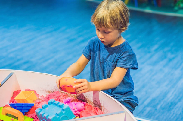 Boy playing with kinetic sand in preschool. The development of fine motor concept. Creativity Game concept. - Foto, Imagen