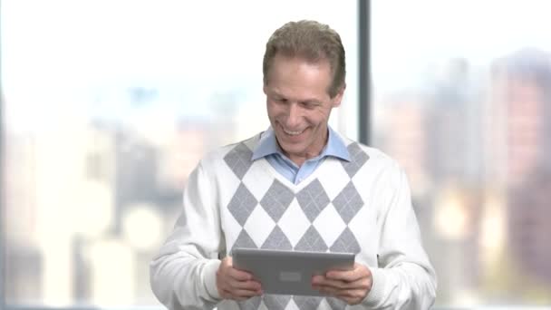 Funny middle-aged man playing on digital tablet. - Footage, Video
