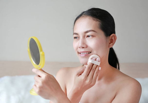 Beauty asian woman applying makeup with Sponge Powder Puff. Woman make up herself. - Valokuva, kuva