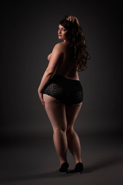 Plus size sexy model in underwear, fat woman on gray studio background, overweight female body, full length portrait, rear view - Fotoğraf, Görsel