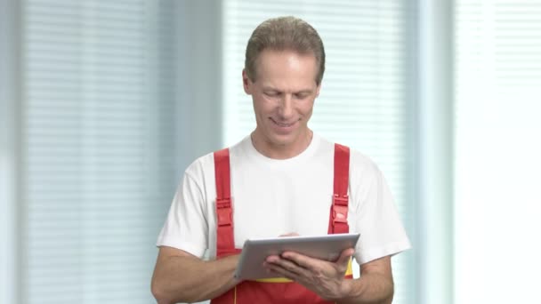 Glücklicher Bauarbeiter mit PC-Tablet. - Filmmaterial, Video