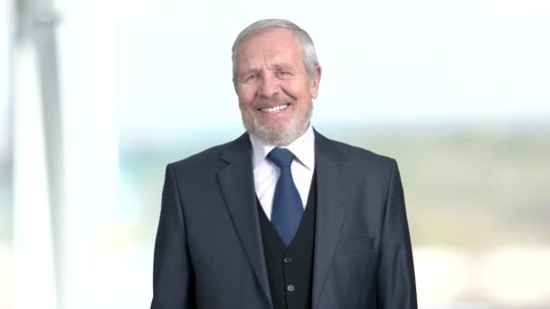 Elderly businessman is laughing, blurred background. - Footage, Video