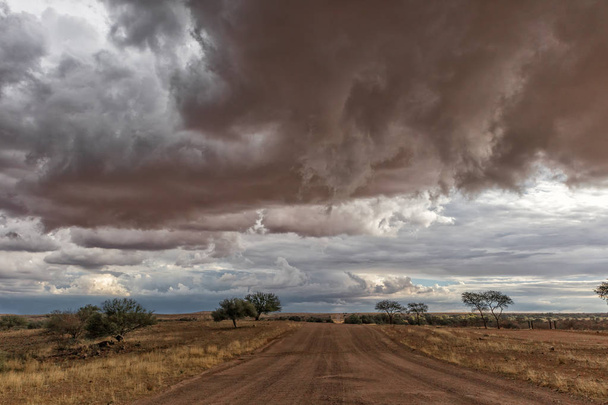 Kavics road úton, a Namíbiai sivatagban, rendkívül drámai ég, vihar. - Fotó, kép