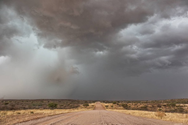 Гравійні дороги по дорозі в Намібії пустелю з надзвичайно драматичні небо, буря. - Фото, зображення