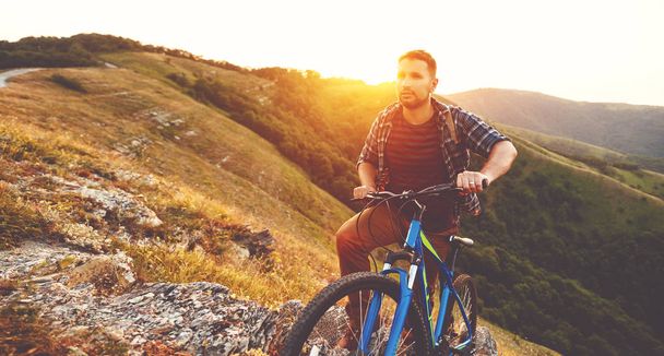 їзда на велосипеді. молодий чоловік з велосипедом на природі в горах
   - Фото, зображення