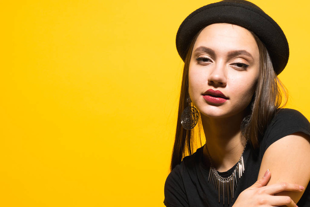 attractive confident girl in black fashionable hat posing, expensive earrings and necklace - Foto, Imagen
