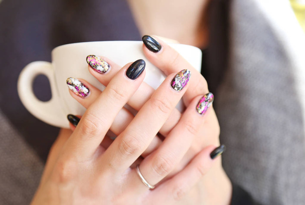 Frauenhände mit schöner Maniküre halten eine Tasse Kaffee - schwarzer Lack mit modischen Formen - Foto, Bild