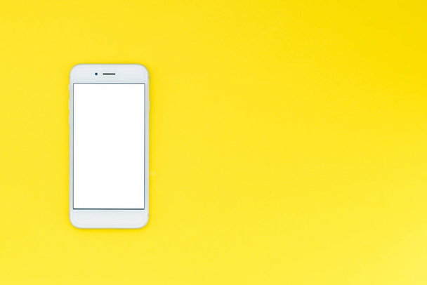 weißes modernes Smartphone auf gelbem Hintergrund. flache Lage - Foto, Bild