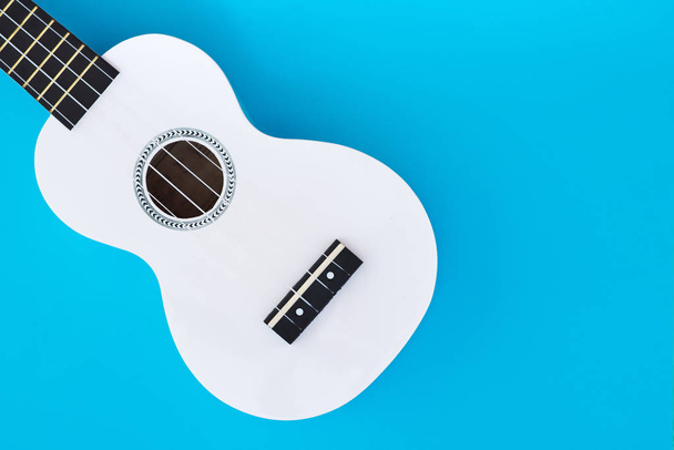 Beyaz Hawai gitar, ukulele mavi bir arka plan üzerinde. Müzik konsepti. Düz Lay şablon. Metin için yer - Fotoğraf, Görsel