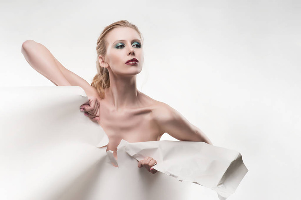 Beautiful topless girl tears a large sheet of white whatman pape - Fotografie, Obrázek