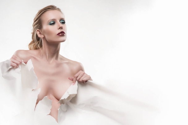 Beautiful topless girl tears a large sheet of white whatman pape - Fotografie, Obrázek