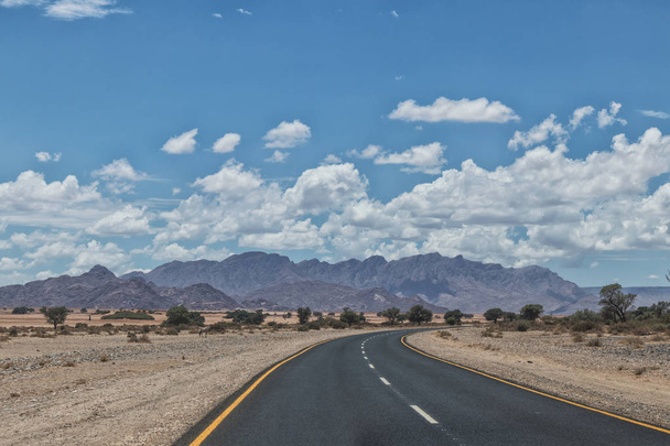 Asphalt road with mountains on horizon, Namibia. - Photo, Image