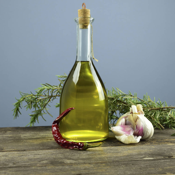 italienisches Olivenöl in Flaschen mit aromatischen Kräutern - Foto, Bild