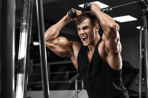 Hombre musculoso haciendo ejercicio en el gimnasio, culturista fuerte macho
  - Foto, Imagen