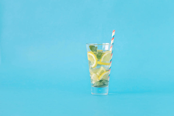 Refreshing summer cocktail with lemon and mint on blue background - Fotó, kép