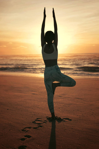 Urheilullisen nuoren naisen siluetti joogaharjoituksissa rannalla, terveen elämän käsite ja luonnollinen tasapaino kehon ja henkisen kehityksen välillä
 - Valokuva, kuva