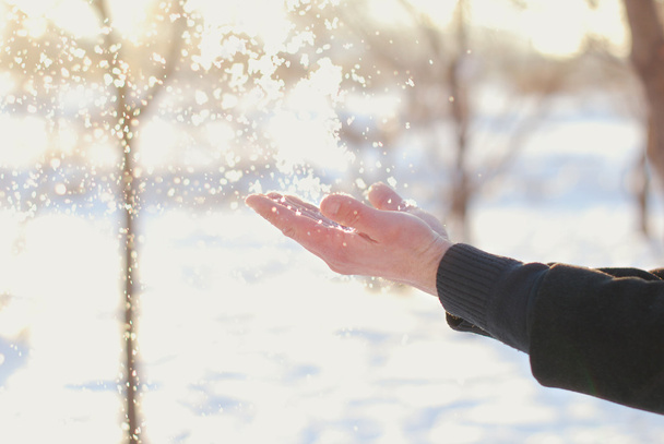 Vallende sneeuw op de man handen - Foto, afbeelding
