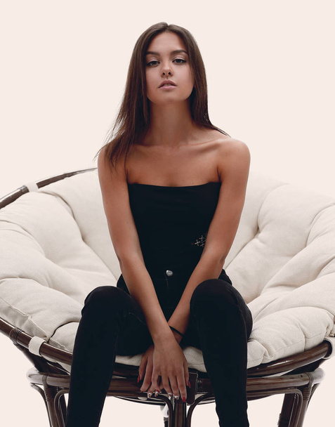 jovem mulher sentada em uma poltrona grande confortável
 - Foto, Imagem