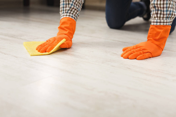Hombre irreconocible limpiando piso con trapo
 - Foto, Imagen