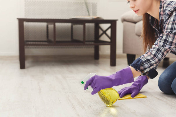 Concentrated woman polishing wooden floor - Photo, Image