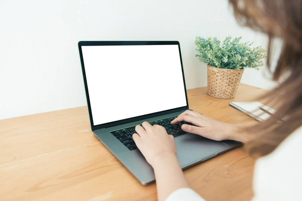 Mladá asijská žena pracující pomocí a psaní na notebooku s vzorovou prázdná bílá obrazovka, zatímco doma v kanceláři pracovního prostoru. Podnikatelka pracující z domova přes přenosný počítač. Využívat čas doma. - Fotografie, Obrázek