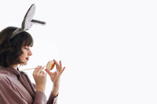 όμορφη γυναίκα ζωγραφική Πασχαλινό αυγό που απομονώνονται σε λευκό φόντο με αντίγραφο χώρου - Φωτογραφία, εικόνα