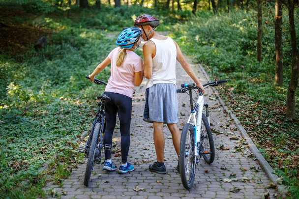 Любящие молодые люди встретились в парке. Езжай на велосипедах. The conce
 - Фото, изображение