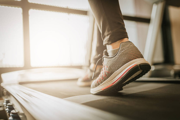 Крупним планом знімок жіночої ноги біжить у спортзалі на біговій доріжці для вправ. фітнес і концепція здорового способу життя
 - Фото, зображення