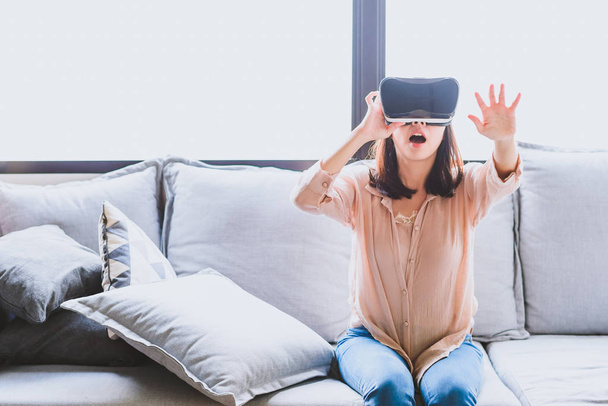 Знімок збудженої жінки в гарнітурі VR у вітальні
 - Фото, зображення