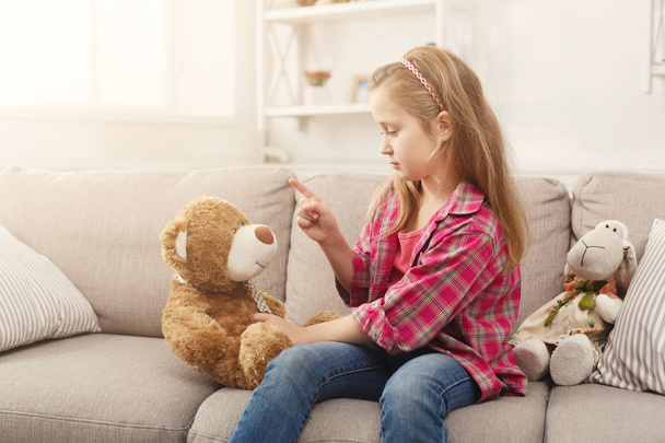 κοριτσάκι παίζει με αρκουδάκι στο σπίτι - Φωτογραφία, εικόνα