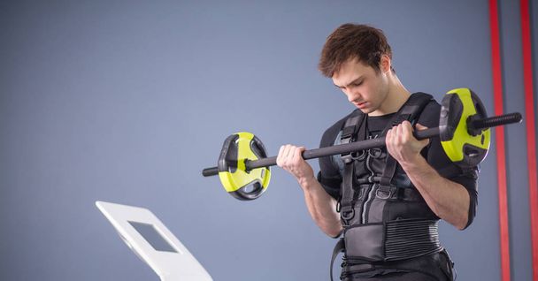 Man working out EMS training with barbell closeup, power pose - Photo, image